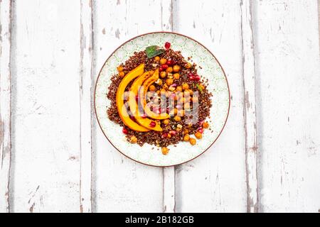 Studio Schuss Salat aus rotem Quinoa mit gebackenen Kürbis, Kichererbsen, Granatapfel, Basilikum, Walnüsse und Kürbiskerne Stockfoto