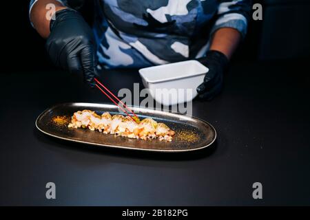 Nahaufnahme des Küchenchefs, der ein Gericht in der Restaurantküche zubereitet Stockfoto