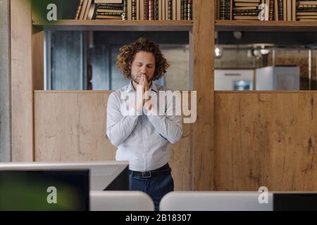 Portrait von heiteren Geschäftsleuten, die im Büro meditieren Stockfoto