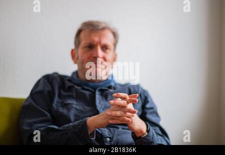 Mainz, Deutschland. Februar 2020. Gerhard Trabert, Sozialmediziner, sitzt während der Redaktionssitzung mit der Deutschen Presse-Agentur auf dem grünen Sofa. Kredit: Andreas Arnold / dpa / Alamy Live News Stockfoto