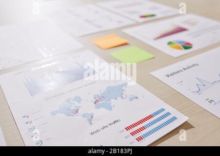 Verschiedene Finanzdokumente mit Berichten, Diagrammen und Diagrammen auf Bürotisch, ausgewählter Fokus Stockfoto