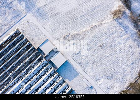 Verlassenes und zerbrochenes schneebedecktes Gewächshaus auf dem Land. Draufsicht Luftbild Stockfoto