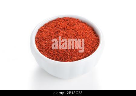 Paprika gemahlen in einer weißen Schüssel auf weißem Grund. Zum Farben von Ritzen, Eintöpfen und Suppen, Fleisch. Stockfoto