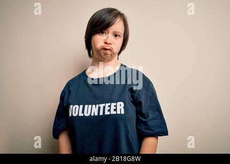 Junge Daunensyndrom-Freiwilligenfrau, die Sozialfürsorge trägt, ist depressiv und sorgt sich um Not, weinend wütend und ängstlich. Trauriger Ausdruck. Stockfoto
