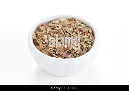 Gemahlen getrocknete Basil (Sweet Basil) in einer weißen Schüssel auf weißem Grund. Wird als Gewürz in kulinarischem Kraut auf der ganzen Welt verwendet. Stockfoto