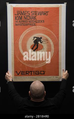 Der Prop Store Posterberater Mark Hochman betrachtet ein US-One-Sheet-Poster für den Film "Vertigo" aus dem Jahr 1958 (Schätzung £1k - £2k) während einer Vorschau für die bevorstehende Kinoposter-Auktion des Prop Store. Stockfoto