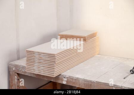Weiß gestapelte Fliesen auf Holzgerüsten, Nahaufnahme, horizontales Bild, Seitenansicht Stockfoto