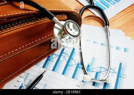 Konzept Der Gesundheitsaktien. Business-Aktentasche, Stethoskop und Finanzmarktdiagramme. Stockfoto