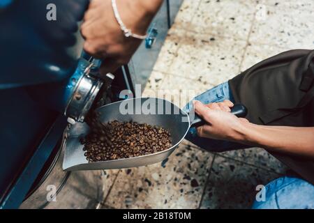 Frau, die Kaffee Bohnen aus dem Speicher Stockfoto