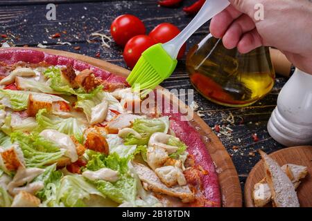 Ungewöhnliche Pizza mit Hühnerfleisch, Scheiben Weißbrot, Kohl, Tomatenmark und Mayonnaise. Stockfoto