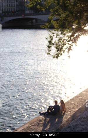 Paris, Frankreich. Liebespaar Sitzt an der seine. Unscharfe Romantische Pariser Lebenswelt. Stockfoto