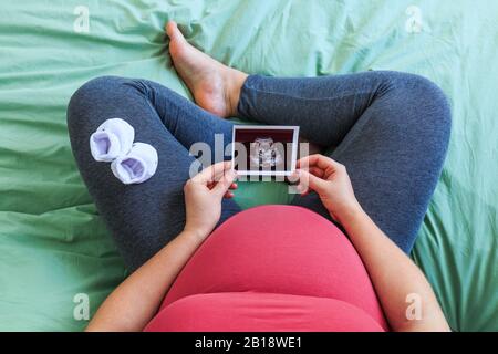 Schwangere Frau mit Ultraschall Bild. Konzept der Schwangerschaft, Gesundheit, Gynäkologie, Medizin. Junge Mutter warten auf das Baby. Close-up, kopieren Spa Stockfoto