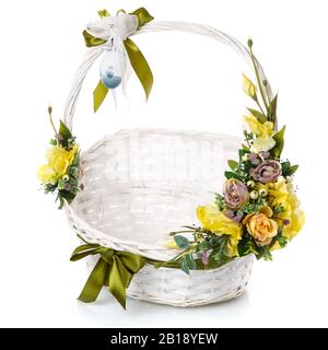 Weidenkorb weiß mit Blumenarrangement in olivfarbener Farbe. Isoliert. Stockfoto