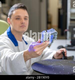 Qualitätsingenieur untersucht eine Probe, die mit einem Laser auf einem 3D-Scan in einem Forschungslabor gescannt wurde Stockfoto