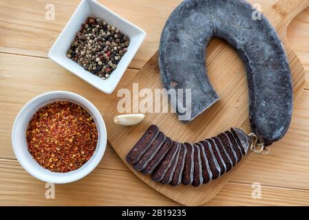 Schneiden Sie Scheiben der speziellen Pirot-Hufeisenwurst - Peglana Pirotska kobasica, aus Kalbfleisch, Schaf- und Ziegenfleisch, mit Zusatz von Knoblauch Stockfoto