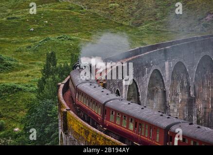 Die Jacobite Dampfeisenbahn, die Dampf auf ihr ausbläst, überquert den Glenfinnan Viaduct, Glenfinnan, Inverness-shire, Schottland Stockfoto