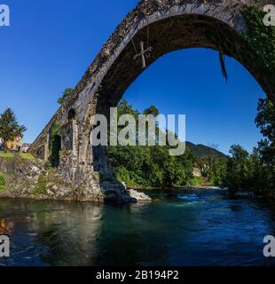Dreifache Bogenbrücke über den Fluss Sella, Cangas de Onis, Asturien, Spanien. Die Brücke ist lokal als Römerbrücke bekannt. Obwohl es o gebaut wurde Stockfoto