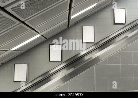 Vier große vertikale/Hochformat-Leere Werbetafel mit Rolltreppe im Hintergrund. Stockfoto