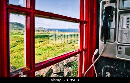 Blick auf den Atlantik von der traditionellen roten Telefonbox, Ardnamurchan-Halbinsel, Lochaber, Highland, Schottland Stockfoto