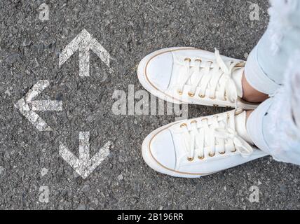 Draufsicht von selfie White Working man Schuhe stehen auf Holzfußboden mit grau gezogenen drei Richtungspfeilen, Entscheidungsfindung, Choices conc Stockfoto