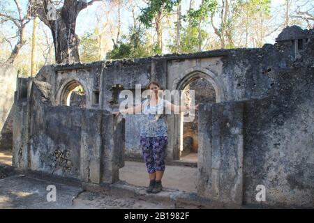 Die alte verlassene arabische Stadt Gede in der Nähe von Malindi, Kenia. Classic Swahili Architektur und White Tourist Girl Stockfoto