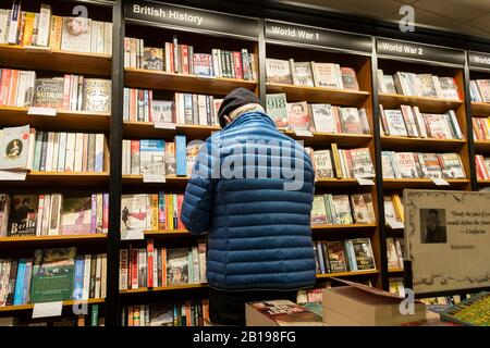 Ein Kunde, der im Abschnitt "Geschichte" in einem Waterstones Book Shop Book Store stöbere. Stockfoto