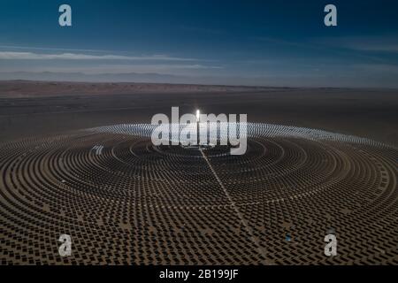 Die Luftaufnahme einer solarthermischen Anlage nutzt Spiegel, die die Sonnenstrahlen auf einem Sammlungsturm fokussieren, um erneuerbare und umweltfreie Energie zu erzeugen. Stockfoto