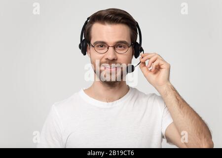 Gutaussehender junger Mann mit drahtlosem bluetooth-headset mit Mikrofon. Stockfoto