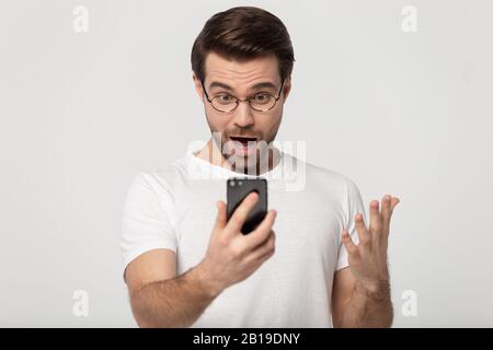 Schockiert positiver glücklicher junger Mann kann nicht an sein Glück glauben. Stockfoto