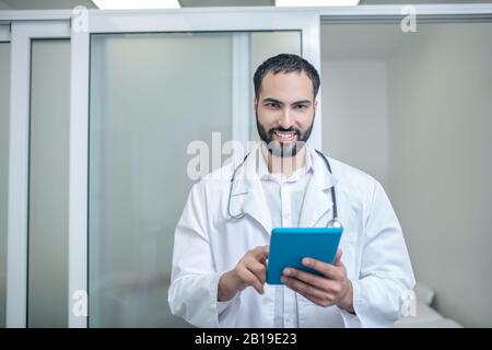 Männlicher Arzt in einer weißen Robe fühlt sich gut an Stockfoto