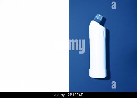 Weiße Kunststoffflasche mit Reinigungsprodukt, Haushaltschemikalien oder flüssigem Waschmittel auf klassischem blauem Hintergrund. Draufsicht. Flaches Lay. Kopierbereich. Waschmittelflasche. Stockfoto