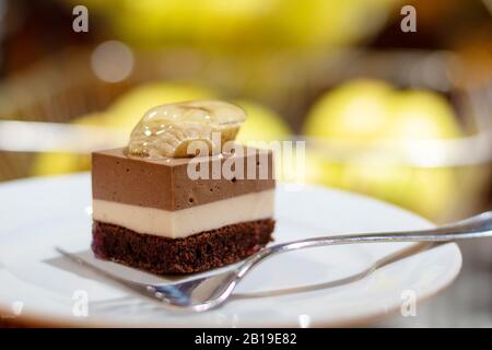 Dreifacher Schokoladenmousse mit Banane auf weißem Teller. Stockfoto