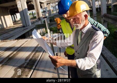 Ingenieur, Unternehmer, Architekt, Teamarbeit. Bau die Menschen reden und Planung arbeiten, Blaupause Stockfoto