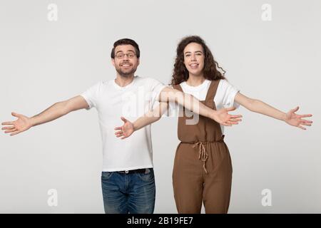 Aufgeregt lächelnde, tausendjährige Paare, die Kunden begrüßen, freuen sich, Freunde zu sehen. Stockfoto