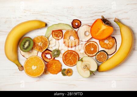 Holzhintergrund mit frischen Früchten und Fruchtchips. Blick von oben. Stockfoto