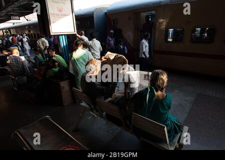 Zeitung lesen, warten auf den Zug. Bahnhof Tirupati, Andhra Pradesh. Südindien. Stockfoto