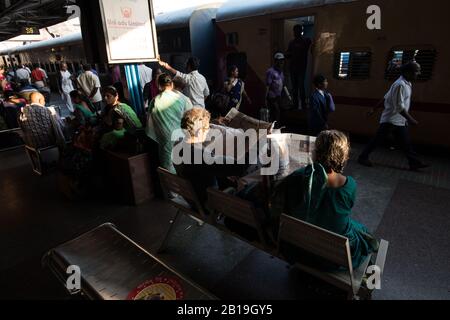 Zeitung lesen, warten auf den Zug. Bahnhof Tirupati, Andhra Pradesh. Südindien. Stockfoto