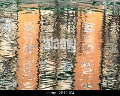 Bilder von farbenfrohen Gebäuden, die sich in den gewellten Gewässern des Sees widerspiegeln.Hintergrundtextur Stockfoto