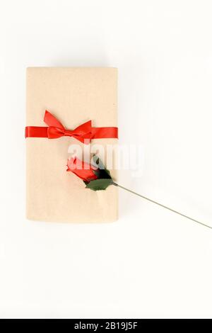 Geschenk in Kraftpapier mit einer roten Rose verpackt Stockfoto