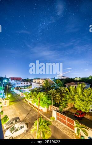 Milchstraße auf Mauritius. Sterne über Häusern und Bäumen. Stockfoto