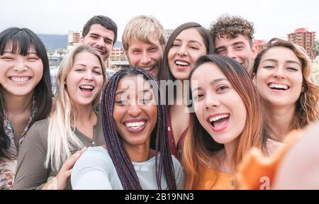 Fröhliche Freunde aus verschiedenen Kulturen und Rassen, die Fotos machen, lustige Gesichter machen - Jugend, tausendjährige Generation und Freundschaftskonzept mit Jugendlichen Stockfoto