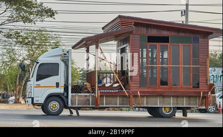 Ein kleines Holzhaus, das auf einem Lastwagen transportiert wird. Stockfoto