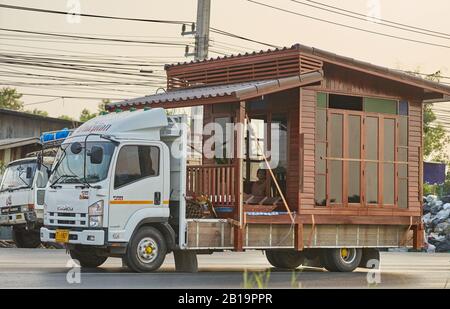 Ein kleines Holzhaus, das auf einem Lastwagen transportiert wird. Stockfoto