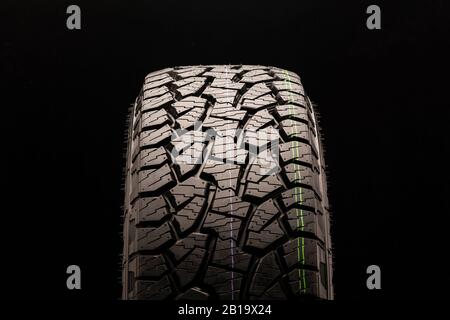 Alle Geländereifen für Geländewagen mit schwarzem Hintergrund in Nahaufnahme anschlamm. Vorderansicht des Rades, die Lauffläche ist gut zu erkennen Stockfoto