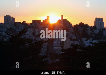 Der Sonnenuntergang unter den Gebäuden Stockfoto