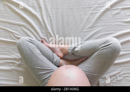 Draufsicht über die Erwartung einer schwangeren Frau im Bett-, Schwangerschafts- und Geburtskonzept Stockfoto