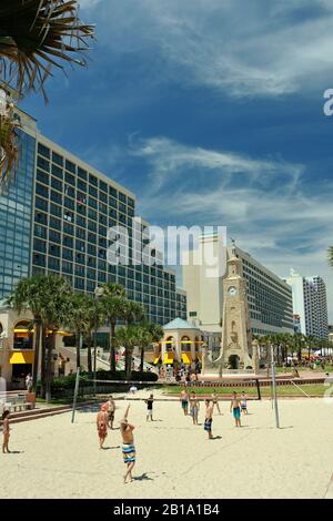 Spiel des Beachvolleyballs, Daytona Beach, Florida, Vereinigte Staaten von Amerika, mit dem Coquina Clock Tower im Hintergrund. Stockfoto