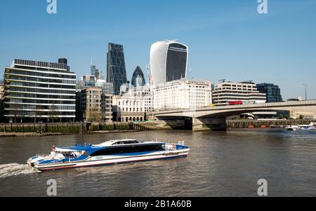 London River Bus. Eine MBNA Thames Clipper an der Themse mit London Bridge und den dahinter liegenden finanziellen Wolkenkratzern der City of London. Stockfoto