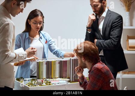 Kreativ selbstbewusstes Team von Ingenieuren, die in einem Architektenstudio zusammenarbeiten, Nahaufnahme: Architekten planen, entwerfen und beaufsichtigen den Bau Stockfoto