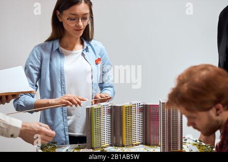 Junge Frau in stilvollem blauem Hemd und weißem Oberteil lernt, Modelle zu messen, zu üben, ihre künstlerischen Fähigkeiten zu entwickeln, Nahaufnahme Foto. Bildung.effo Stockfoto